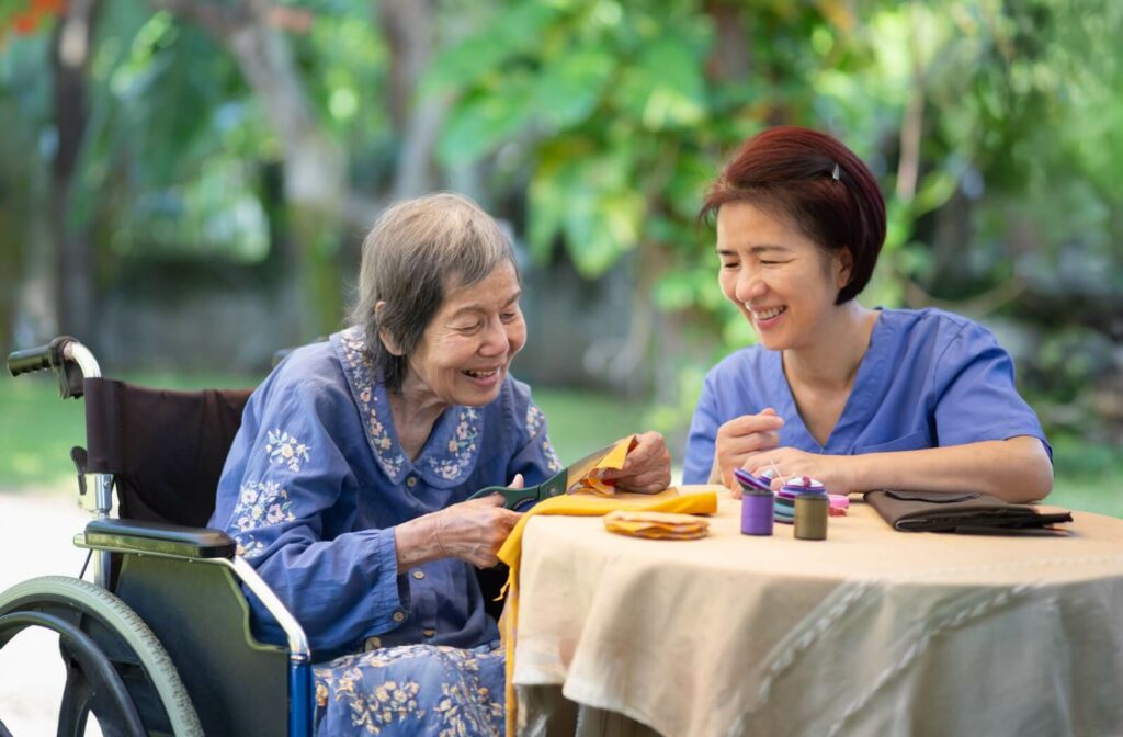 A nurse helps a senior with dementia engage in outdoor arts & crafts as therapy in memory care